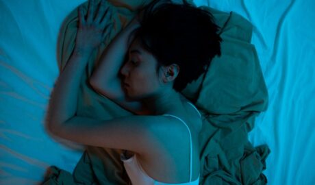 A woman lying on her bed feeling a void of emptiness.