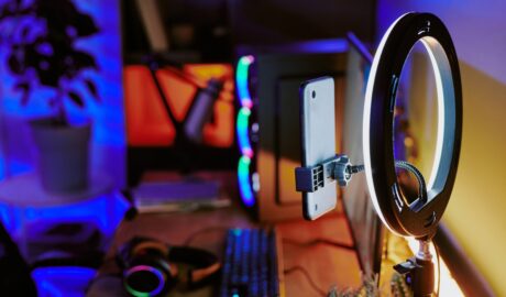4 Ways to Set Up a Professional Streaming Studio: A Step-by-Step Guide 4 An online streaming studio setup. A gaming PC, keyboard, monitor, headphones, and a ring light sit on a wooden desk.
