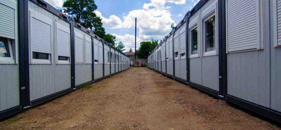 An office mobile building made out of a shipping container with two front doors and two small square windows.