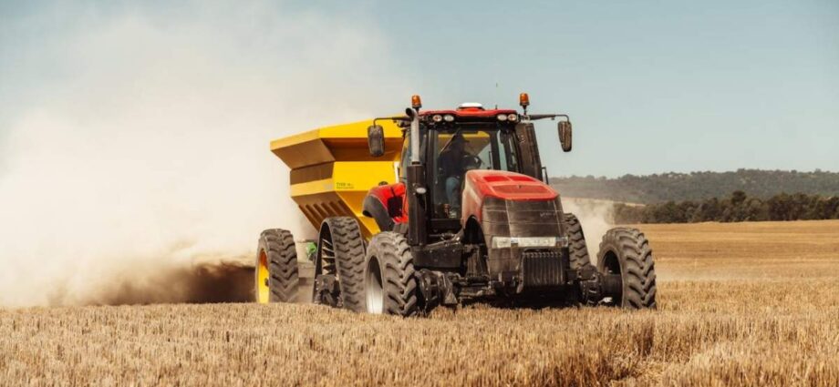A tractor harvesting in the field as part of modern farming intiaitves.