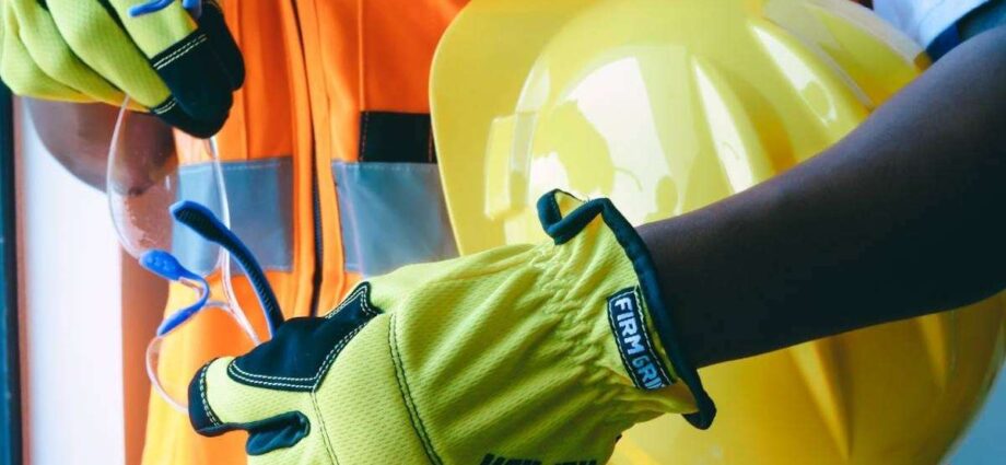 A construction worker wearing yellow gloves.