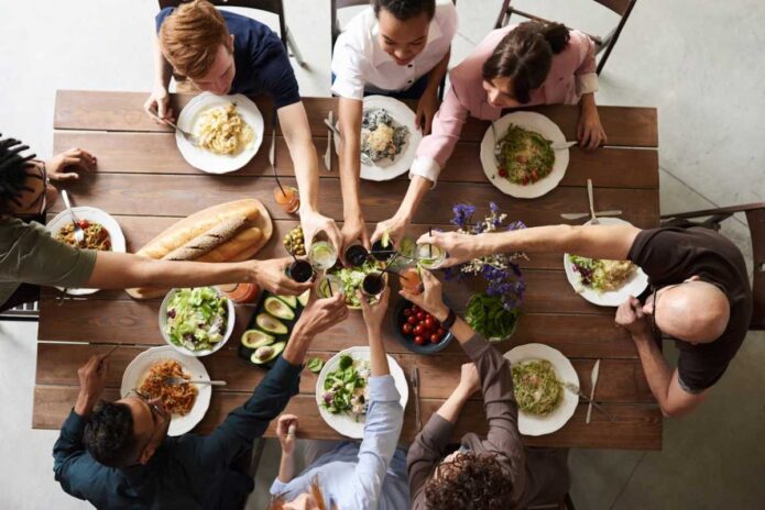 Restaurant-Worthy Dinners You Can Make in Your Own Kitchen 5 People sitting at a dinning table having a prepared dinner together.