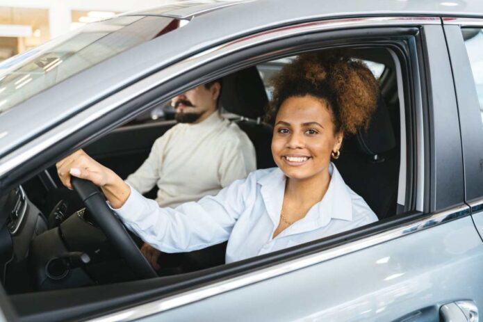 A smiling woman inside a car. How Preventive Maintenance Leads to Safer Driving - Newslibre
