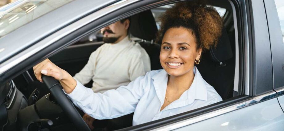 A smiling woman inside a car. How Preventive Maintenance Leads to Safer Driving - Newslibre